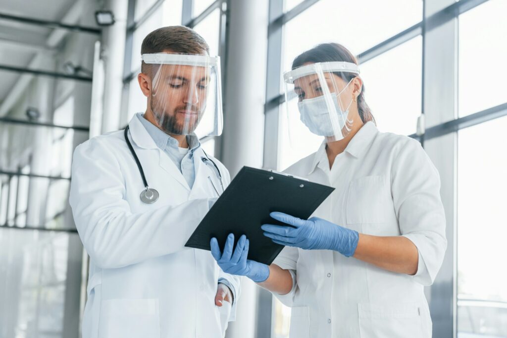 Working with documents. Two doctors in white coats is in the clinic